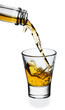 Whiskey being poured into a glass isolated on white