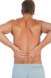 Shirtless man suffering from lower back pain