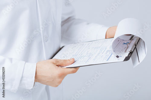 Photo: male doctor holding prescription paper in hand male doctor holding prescription paper in hand