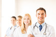 Photo: male doctor in front of medical group male doctor in front of medical group