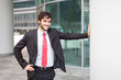 Foto: Businessman leaning on a metal column Businessman leaning on a metal column