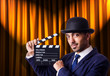 Man with movie clapper on curtain background