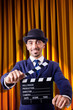 Man with movie clapper on curtain background
