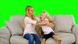 Daughter jumping in the arms of her mother on green screen
