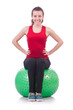 Young woman with ball exercising on white