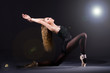 Ballerina dancing in the dark studio