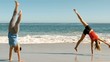 Attractive women doing cartwheels in front of the sea