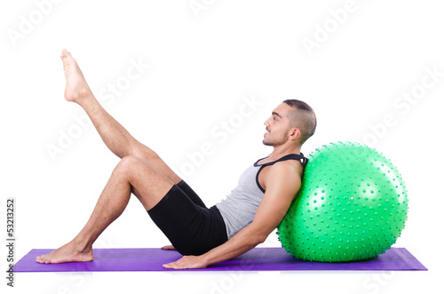 Photo: Man with swiss ball doing exercises on white Man with swiss ball doing exercises on white