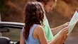 Couple reading map on side of the road