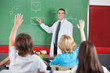Photo: Teacher Teaching While Students Raising Hands Teacher Teaching While Students Raising Hands