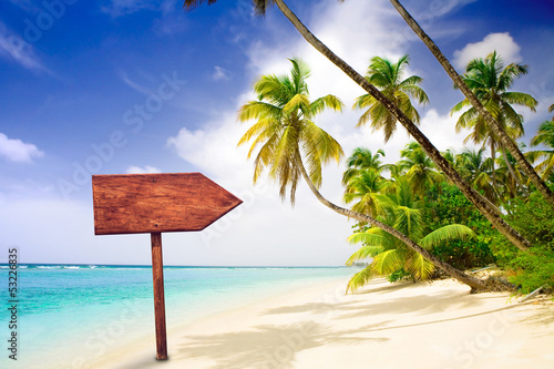Photo: empty wooden signpost at tropical beach empty wooden signpost at tropical beach