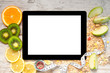 tablet computer with fruit and a measuring tape for weight loss