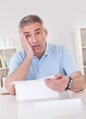 Horrified old man reading a letter