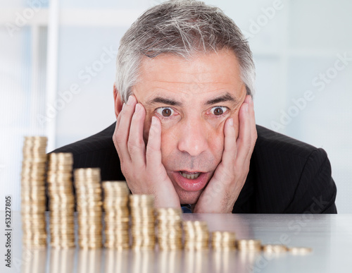 Photo: Shocked Businessman With Stack Of Coins Shocked Businessman With Stack Of Coins