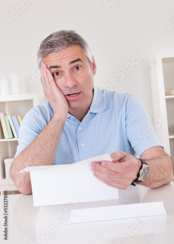 Photo: Horrified old man reading a letter Horrified old man reading a letter