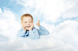 Foto: child lying down on cloud pillow over blue sky child lying down on cloud pillow over blue sky