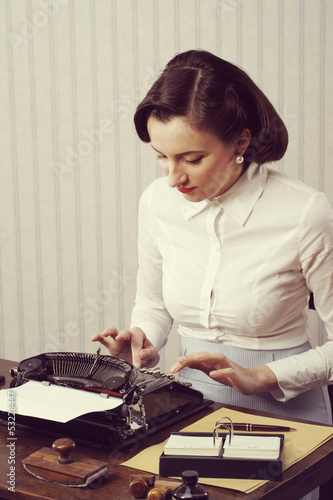 Photo: Woman typing in her office Woman typing in her office