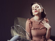 Foto: Woman cooling herself with fan Woman cooling herself with fan