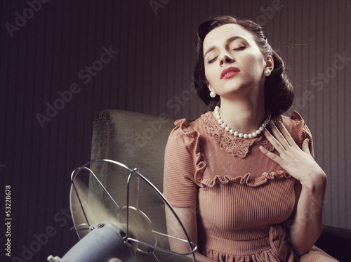 Photo: Woman cooling herself with fan Woman cooling herself with fan