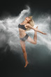 Dancer jumping into white powder cloud