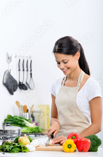 Photo: Smiling woman in the kitchen preparing healthy meal Smiling woman in the kitchen preparing healthy meal