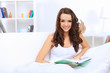 Young woman at home with a book