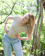The young slender woman does sporting training in park