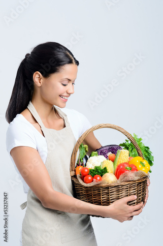 Photo: Attractive woman holding a basket of vegetables Attractive woman holding a basket of vegetables