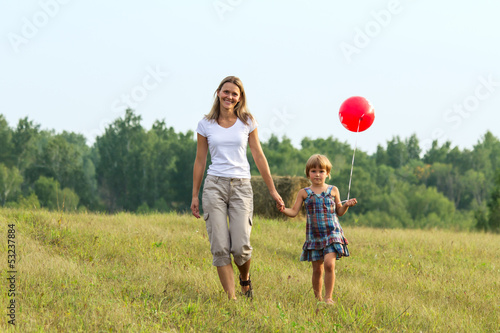 Photo: Mother and daughter go forward with ball in hand Mother and daughter go forward with ball in hand