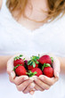 Woman holding strawberries in her hand