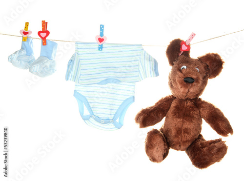 Photo: Baby clothes hanging on clothesline, isolated on white Baby clothes hanging on clothesline, isolated on white
