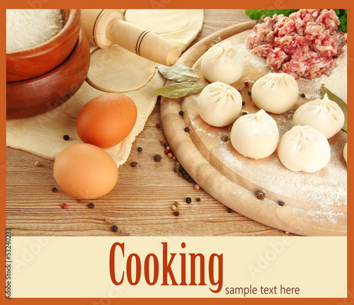 Photo: Raw dumplings, ingredients and dough, on wooden table Raw dumplings, ingredients and dough, on wooden table