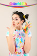 Photo: Young pretty painter with hands in paint, on gray background Young pretty painter with hands in paint, on gray background