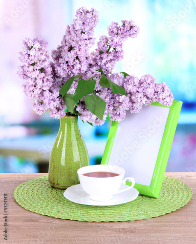Photo: Beautiful lilac flowers on table in room Beautiful lilac flowers on table in room