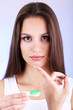 Young woman putting contact lens in her eye close up