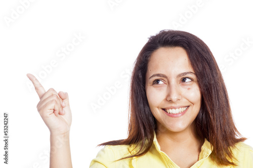 Photo: Smiling young casual woman pointing her finger to copy space Smiling young casual woman pointing her finger to copy space