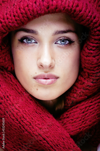 Photo: young pretty woman in sweater and scarf all over her face young pretty woman in sweater and scarf all over her face