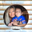 Mother and son peeks through hole at playground