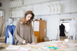 Photo: Fashion designer cutting fabric textile in a studio Fashion designer cutting fabric textile in a studio