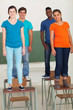 group of high school students standing on desks