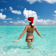 Photo: Woman in santa's hat at beach Woman in santa's hat at beach