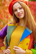 Photo: Beautiful elegant woman standing in a park in autumn Beautiful elegant woman standing in a park in autumn
