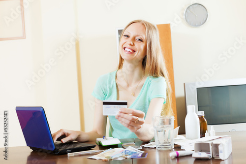 Photo: woman buying drugs online with laptop and card woman buying drugs online with laptop and card