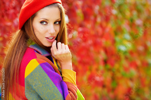 Photo: Beautiful elegant woman standing in a park in autumn Beautiful elegant woman standing in a park in autumn