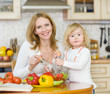 Mother and daughter eating vegetables salad in kitchen