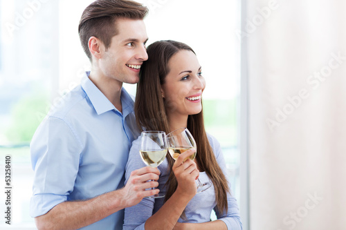 Photo: Couple drinking wine in modern apartment Couple drinking wine in modern apartment