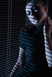 Foto: Sexy woman looking through window with jalousie Sexy woman looking through window with jalousie