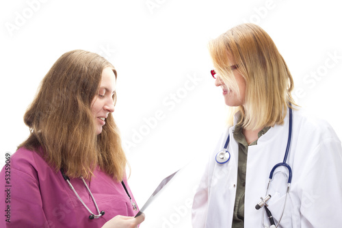 Photo: Two female doctors discussing about a patients health problems Two female doctors discussing about a patients health problems