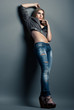 Young sensual woman in jeans over grey