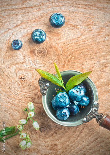 Photo: Blueberries in an old metal ladle and leafs Blueberries in an old metal ladle and leafs